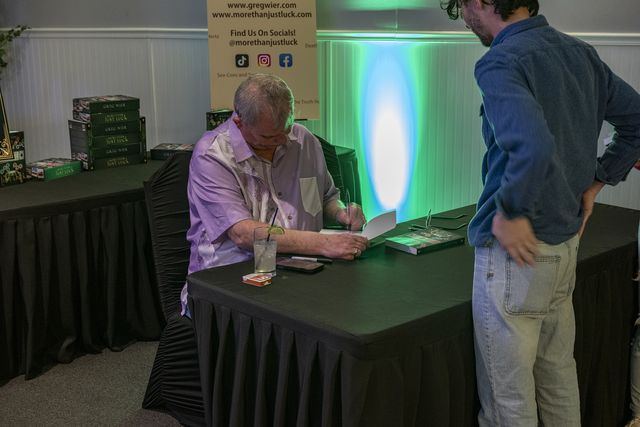 Book release party: A book being signed at the signing table