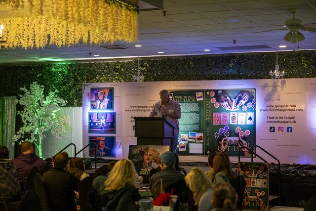 Book release party: Guests seated facing the stage and book display