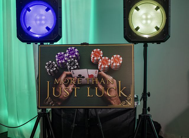 Book release party: More Than Just Luck sign with poker chips between two stage lights