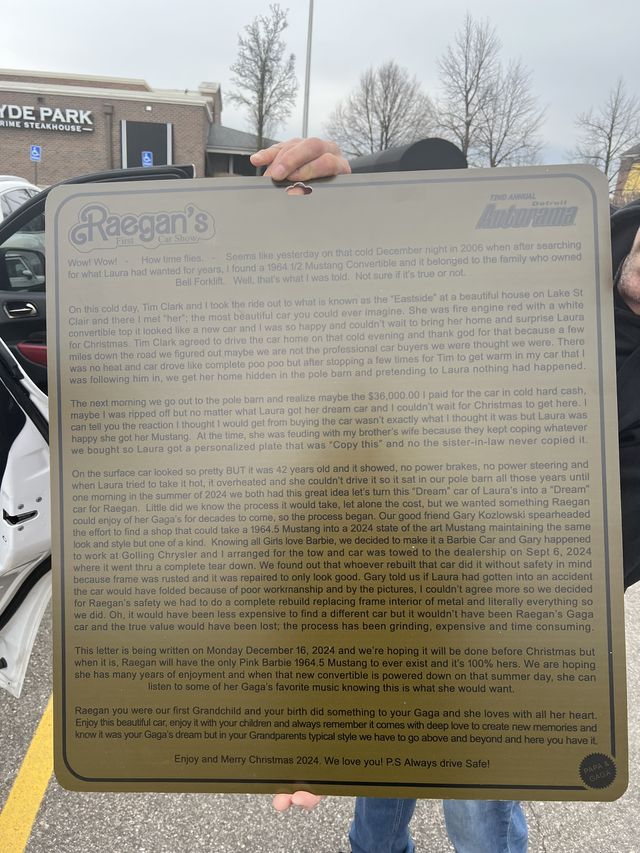 A man holding up a framed certificate