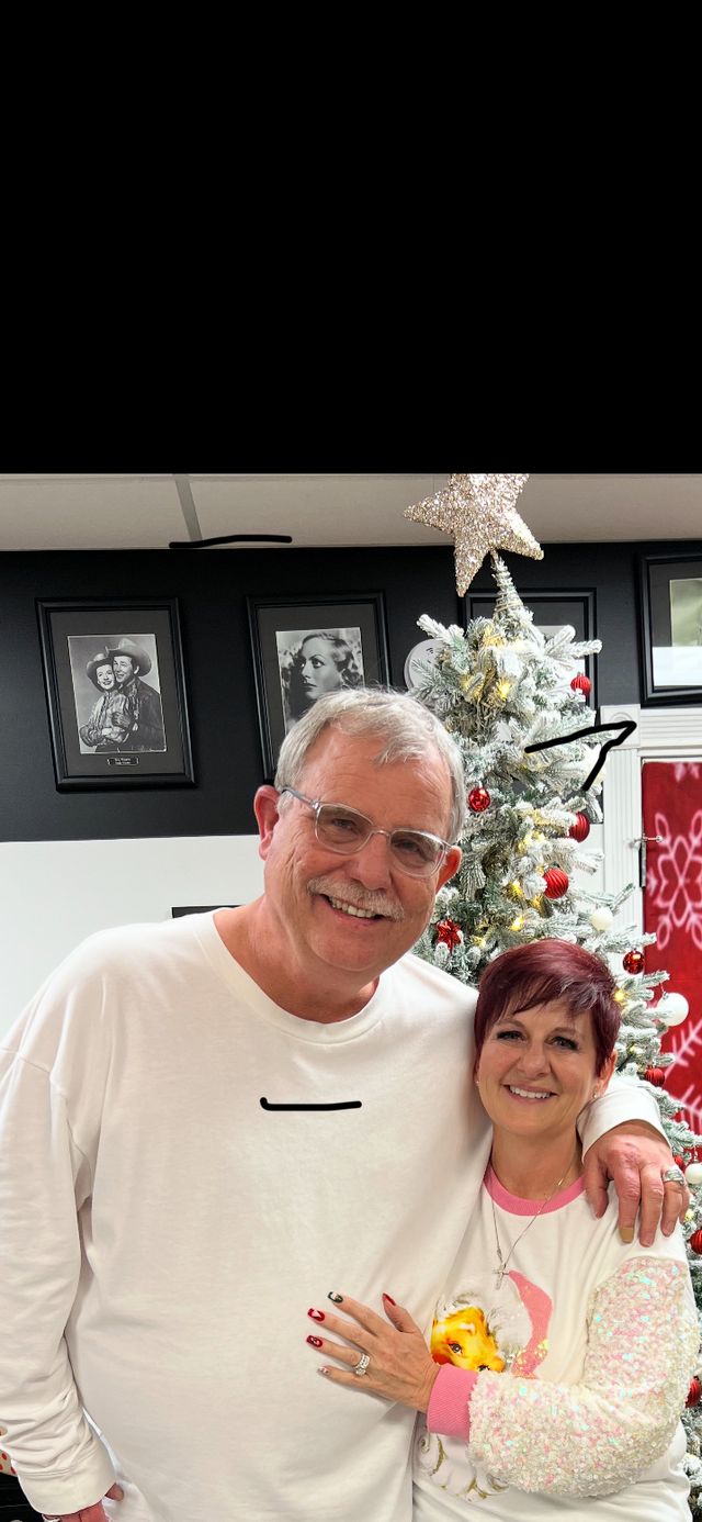 A couple in front of a Christmas tree