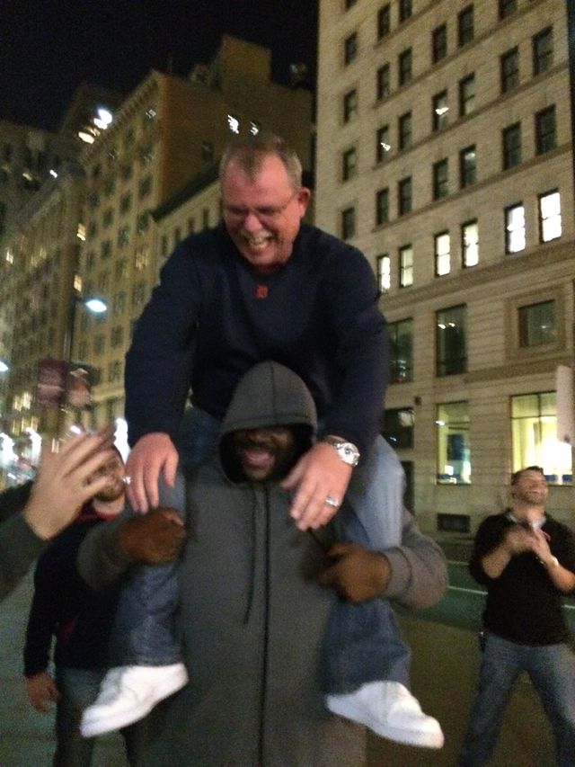 A man riding piggyback on a city street at night