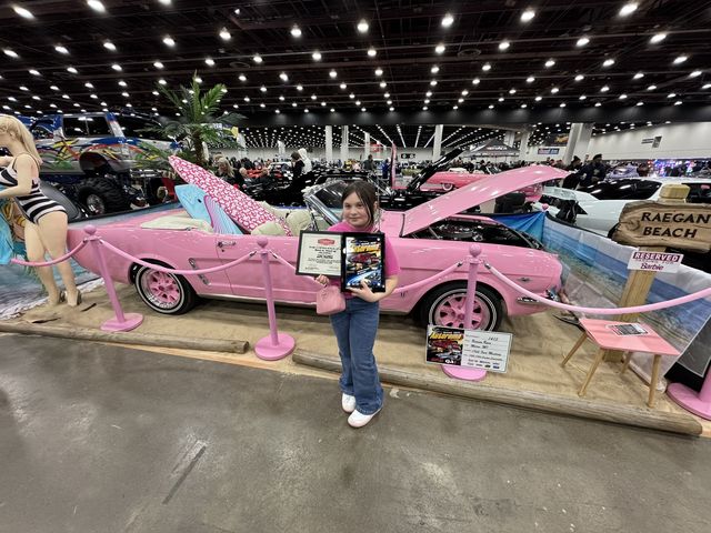 Pink Mustang on display at a car show