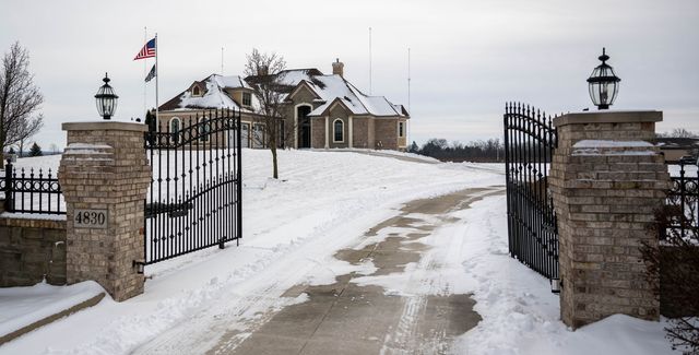 Gated driveway to a large house in the snow