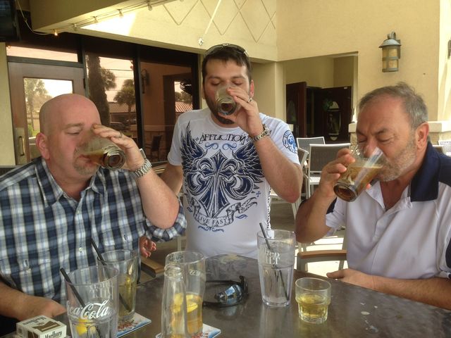 Three men drinking at a table