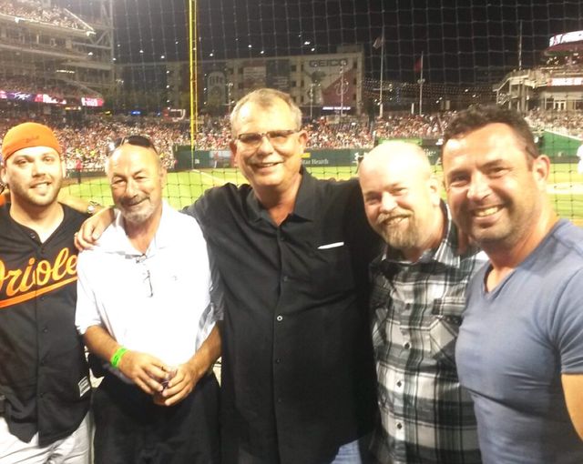 Five men at a baseball stadium at night