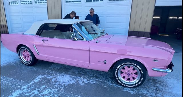 Pink Mustang convertible in a garage