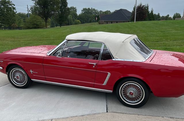 Red Ford Mustang convertible with a white top