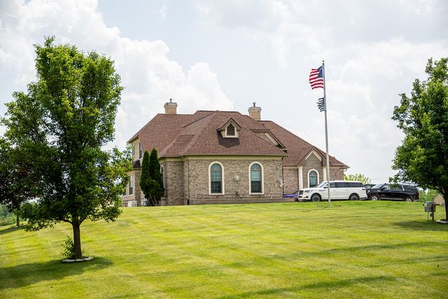 Brick house on a large lawn with a flagpole
