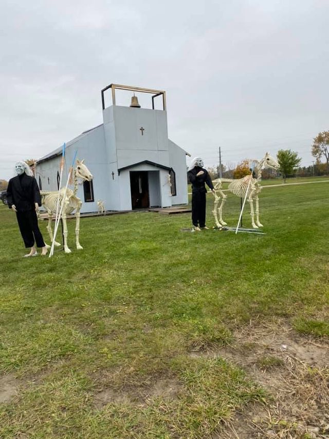 Skeleton horse figures outside a white chapel