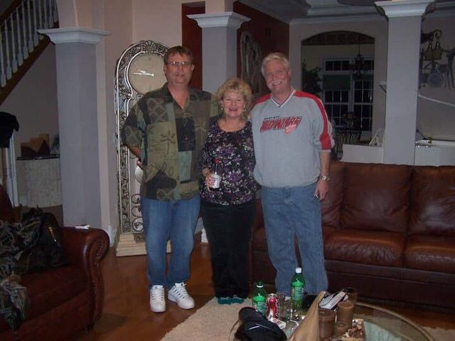 Three people standing together in a living room