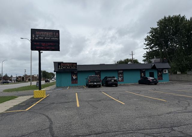 Teal building and parking lot with a tall sign
